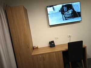 a room with a desk with a television on the wall at NOAZ Hotel Kampala in Kampala