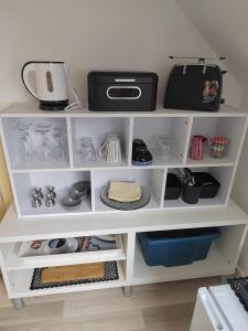 a white shelf with items on it in a kitchen at Séjour près de Bayeux avec Massages et repas en options in Tilly-sur-Seulles