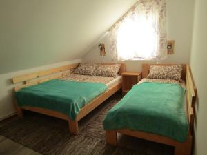 a bedroom with two beds and a window at Hegyi Vendégház in Vărşag