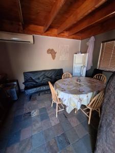a room with a table and chairs and a bed at Nerina 662 in Leeupoort