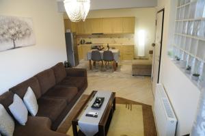 a living room with a brown couch and a kitchen at Franceska's guest house in Artemida