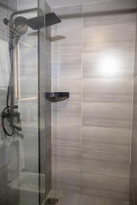 a shower with a glass door in a bathroom at Cozy & Luxury Apartment Lavington, Nairobi in Nairobi