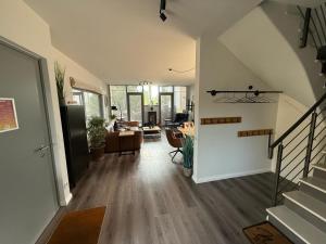 einen Flur eines Hauses mit einer Treppe und einem Wohnzimmer in der Unterkunft Ostsee - Reetdachhaus Nr 42 "Waterkant" im Strand Resort in Heiligenhafen