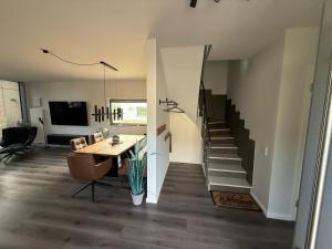 ein Wohnzimmer mit Tisch und Treppe in der Unterkunft Ostsee - Reetdachhaus Nr 42 "Waterkant" im Strand Resort in Heiligenhafen
