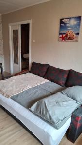 una cama grande en una habitación con un sofá en Mazais Ligzdiņš, en Ventspils