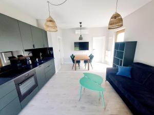 a kitchen and living room with a couch and a table at Leśna24c in Rabka-Zdroj