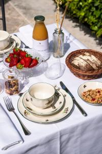 a table with plates of food and strawberries on it at Fiori e Frutti Agriresort in Mestre