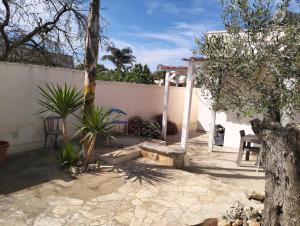 a backyard with a white fence and a tree at Casa Antonio e Nicoletta in Porto Cesareo