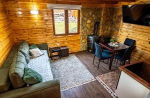 a living room with a couch and a table and a stove at vikendica tarska car in Mitrovac