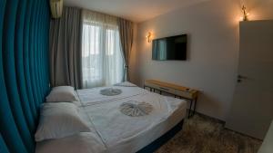 ein kleines Schlafzimmer mit einem Bett und einem Fenster in der Unterkunft GoldenSands Apartments in Goldstrand + 18 Fotos