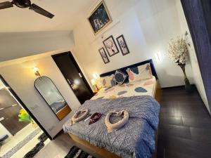 a bedroom with a bed with two towels on it at Harmony Heights By Royal Rooms in Noida
