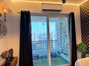 a room with a window with a view of a balcony at Harmony Heights By Royal Rooms in Noida
