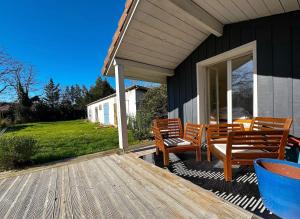 a porch of a house with two wooden chairs at Belle Villa 5 pièces, 3 chambres in Gujan-Mestras