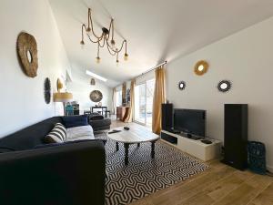 a living room with a couch and a table at Belle Villa 5 pièces, 3 chambres in Gujan-Mestras