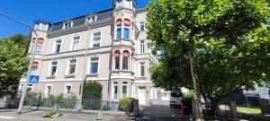 a large white building with a tree in front of it at Idylle Apartments - Park & Therme in Bad Ems