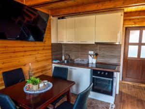 a kitchen with a table and a dining room at vikendica tarska car in Mitrovac