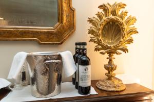 a bottle of wine on a table next to a mirror at Il Palagio Vecchio in Fiesole +78 photos