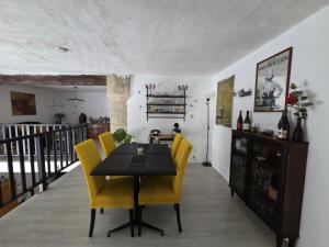 a dining room with a table and yellow chairs at Chez Stéphane et Patricia in Vertaizon