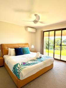 Un dormitorio con una cama grande con ventilador de techo. en Maleny Terrace Cottages, en Maleny