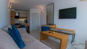 ein Wohnzimmer mit Sofa und Fernseher in der Unterkunft GoldenSands Apartments in Goldstrand