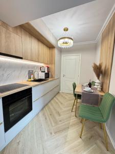 a kitchen with a table and a green chair at Luxury Evergreen Towers by Glam Apartments in Iaşi