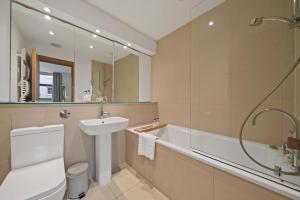 a bathroom with a sink toilet and a tub at Spitalfields Sanctuary 2 Bed 2 Bath 100sqm Aprt in London +11 photos