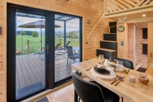 ein Esszimmer mit einem Tisch und einem großen Fenster in der Unterkunft Tiny BlackandWood in Redu + 19 Fotos