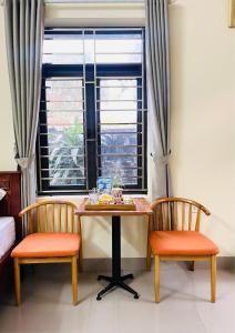 a table and two chairs in a room with a window at Bao Ky Homestay in Nguyên Ngoại