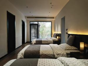 华阴Hua Shan Hidden Spring Exclusive Villa - Entire Private Property 隐泉禅境全栋私邸的一间有两张床和一扇大窗户的卧室