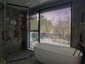 华阴Hua Shan Hidden Spring Exclusive Villa - Entire Private Property 隐泉禅境全栋私邸的带浴缸和大窗户的浴室 更多37张照片