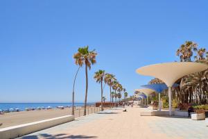 a walkway on the beach with palm trees and the ocean at Casa Andaluza en el centro hisotrico de Estepona - PORTADA 16 in Estepona