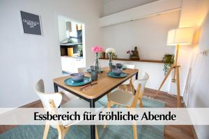 a dining room with a wooden table and chairs at Großzügige 80m2 Gründerzeit FEWO mit privatem Parkplatz, Kingsize Betten, Nobilia Küche, 45 Zoll Smart-TV, 150Mbts WLAN - Nur eine kurzer Spaziergang durch den Park Venedig zur Krämerbrücke - Ausgewählte Empfehlungen für Erfurt inklusive in Erfurt