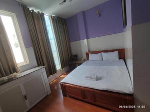 a bedroom with a bed with purple walls and a window at Hotel Phương Linh 360 phạm hùng in Ho Chi Minh City