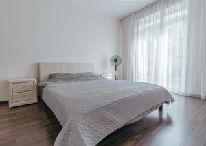 a white bedroom with a bed and a window at Modern Flat near City Center with Parking, Smart TV & Wi-Fi in Rīga