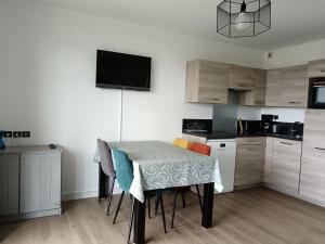 a kitchen with a table and chairs in a room at Cook appartement in Étel