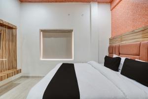 a bedroom with a black and white bed and a window at Hotel O JSB Palace in Kakarmatha +23 photos