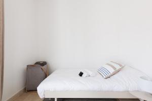 a white bedroom with a bed and a white wall at Une Maison Plein D Options YourHostHelper in Grimaud +32 photos