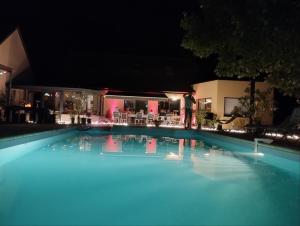 a large swimming pool at night with blue water at Chambres d'hotes PROCHE CIRCUIT in Arnage