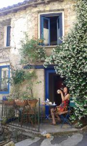 SauveMaisonnette typique, coeur du village médiéval de Sauve的一位女士坐在建筑物前的椅子上