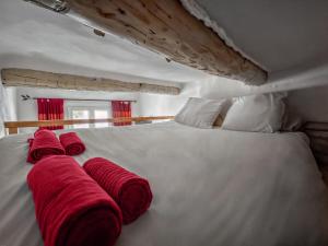 a large white bed with red pillows on it at T2 charmant avec mezzanine au cœur d'Aix in Aix-en-Provence