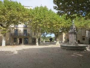 SauveMaisonnette typique, coeur du village médiéval de Sauve的一座建筑前面有喷泉和树木 更多16张照片
