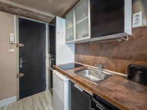 a small kitchen with a sink and a door at T2 charmant avec mezzanine au cœur d'Aix in Aix-en-Provence