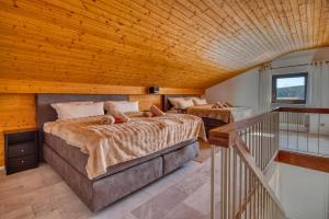 2 Betten in einem Zimmer mit Holzdecke in der Unterkunft Aussicht auf Natur, Pool, Grill, Kino, Sauna in Schönwald