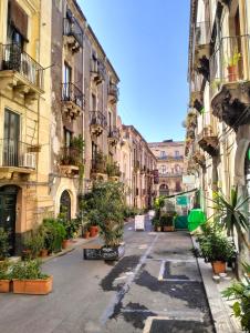 an empty street with potted plants in an alley at Suites della Giudecca in Catania