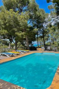 una piscina con sedie e alberi sullo sfondo di Villa Cala del Rey en Sa Riera, Begur Costa Brava a Begur Altre 71 foto