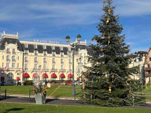 a christmas tree in front of a large building at Appartement, Cabourg Plage, Centre ville - Aquilon in Cabourg +14 photos