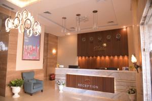 a waiting room with a reception desk and a chair at Dahlia Hotel Apartment Riggae in Kuwait