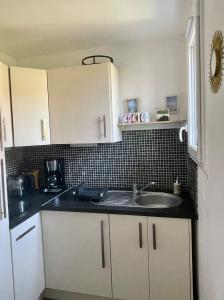 a kitchen with a sink and a counter top at Appartement, Cabourg Plage, Centre ville - Aquilon in Cabourg
