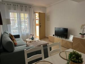 Una sala de estar con un sofá y un televisor. en Casa Tranquila, en San Juan de los Terreros