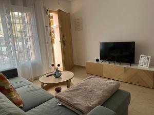 Una sala de estar con un sofá y un televisor de pantalla plana. en Casa Tranquila, en San Juan de los Terreros